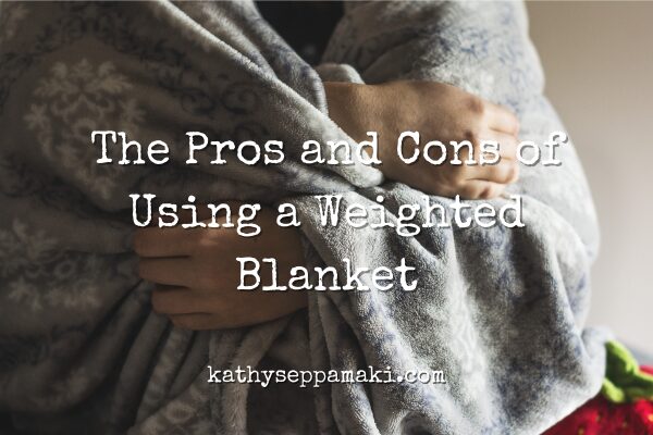 The Pros and Cons of Using a Weighted Blanket blog post title with picture of a woman sitting wrapped in a gray blanket