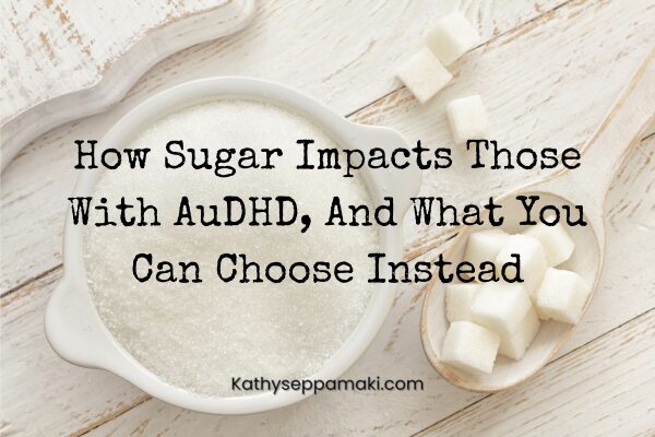 How Sugar Impacts Those With AuDHD, And What You Can Choose Instead blog post title with a picture of a white bowl filled with sugar. Next to is is a white spoon. On the white spoon are several sugar cubes