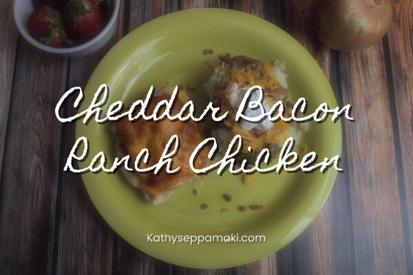 Cheddar bacon ranch chicken blog post title with a picture of the cheddar bacon ranch chicken on a yellow plate. It is paired with a loaded baked potato.