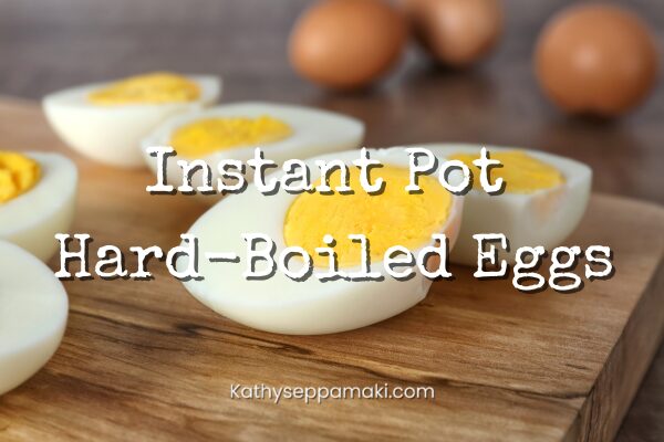 Instant Pot Hard-Boiled Eggs blog post title with picture of hard-boiled eggs that have been cut in half. The eggs are displayed on a wooden cutting board with brown eggs in the background