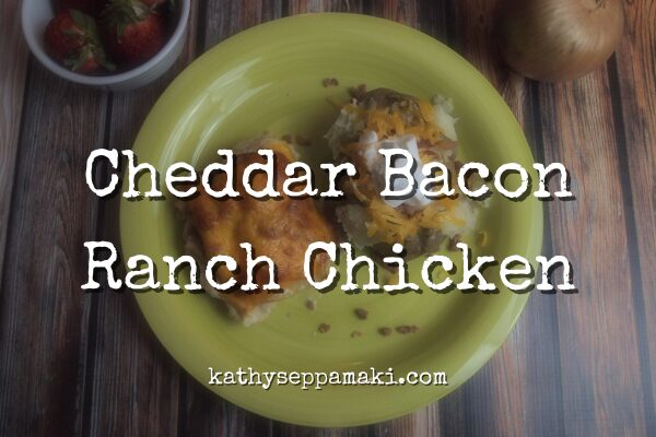 Cheddar bacon ranch chicken blog post title with a picture of the cheddar bacon ranch chicken on a yellow plate. It is paired with a loaded baked potato.